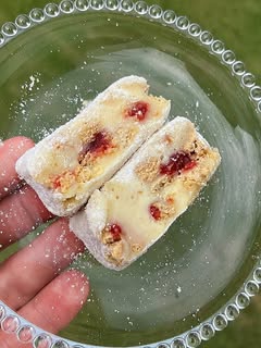 Duas fatias de palha italiana de Ninho com geleia de morango, polvilhadas com açúcar